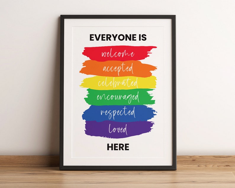 K&ouml;nnte beinhalten: Ein gerahmter Druck mit dem Text "Everyone is welcome, accepted, celebrated, encouraged, respected, loved here" in wei&szlig;en Buchstaben auf einem Regenbogenhintergrund.