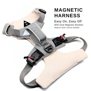 Könnte beinhalten: Ein graues und beiges Hundegeschirr mit zwei Magnetverschlüssen. Das Geschirr hat ein Mesh-Futter und der Text "MAGNETIC HARNESS" und "Easy On, Easy Off" ist auf dem Bild aufgedruckt. Der Text "With Dual Magnetic Buckles" und "Snap to lock | Pull to release" ist ebenfalls auf dem Bild aufgedruckt.