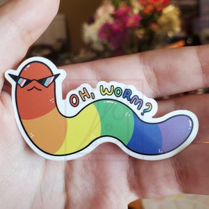 May include: A colorful sticker featuring a cartoon worm in rainbow colors, wearing sunglasses. The sticker has the text "Oh, worm?" in a playful font. The worm is smiling, and the sticker has a white border.