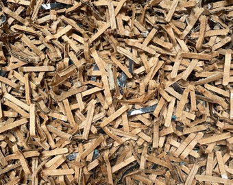 May include: A close-up of brown shredded paper, commonly used as packing material for shipping fragile items.