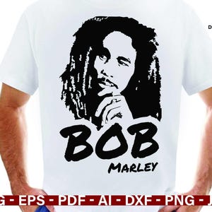 May include: White t-shirt featuring a black and white graphic of Bob Marley. The design includes a portrait of Marley, the name "BOB" in bold letters, and the name "MARLEY" below. The words "DIGITAL DOWNLOAD" are in the upper right corner.