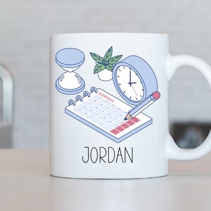 May include: White ceramic mug with a blue and white illustration of a calendar, clock, pencil, and hourglass. The text "JORDAN" is printed on the mug.