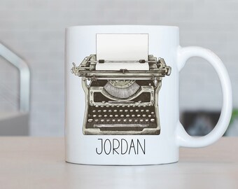 Może przedstawiać: Biały kubek ceramiczny z ilustracją vintage'owej maszyny do pisania i nadrukowanym na dole imieniem "JORDAN".