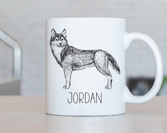 May include: White ceramic mug with a black and white line drawing of a husky dog. The mug has the name "JORDAN" printed on the bottom.