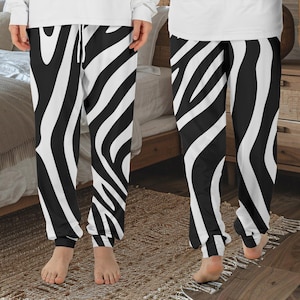 May include: Black and white striped pajama pants with a wavy pattern. The pants have an elastic waistband and a drawstring.