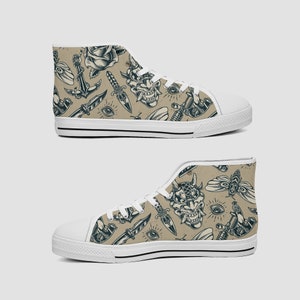 May include: High-top canvas sneakers with a repeating tattoo-style pattern. The design features a rose, anchor, dagger, demon mask, eye, and other tattoo motifs in black on a tan background. The shoes have white soles and laces.