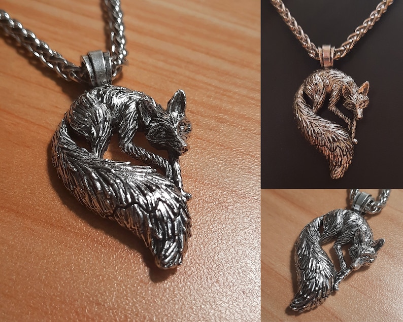 Puede incluir: Un collar con un colgante de plata en forma de zorro enrollado. El colgante es detallado y est&aacute; unido a una cadena de plata.