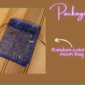 Op de afbeelding: Een marineblauwe mesh tas met een trekkoordsluiting, versierd met gouden sterren en halve manen. De tekst op de afbeelding luidt "Packaging" en "Random-colored moon bag".