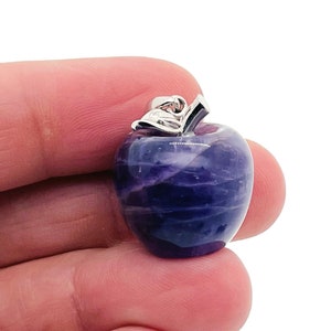 May include: A purple amethyst apple charm pendant with a silver stem and leaf.