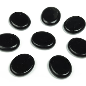 May include: Eight smooth, black oval-shaped stones. The stones are polished and have a glossy finish.
