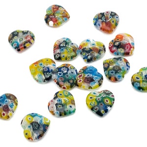 May include: A collection of 15 colorful heart-shaped glass beads with a floral pattern. The beads are scattered on a white background.