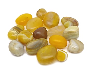 May include: A collection of yellow, brown, and white agate stones. The stones are smooth and polished, with a variety of patterns and textures.