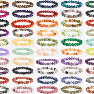 Puede incluir: Una colección de pulseras de cuentas en varios colores, incluyendo rojo, morado, verde y azul. Las pulseras están hechas de cuentas redondas y se muestran en un patrón de cuadrícula. Las pulseras probablemente están hechas de piedras preciosas u otros materiales naturales.