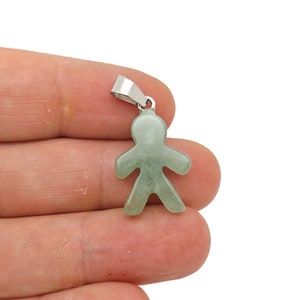 May include: A green jade pendant in the shape of a person with a silver bail.