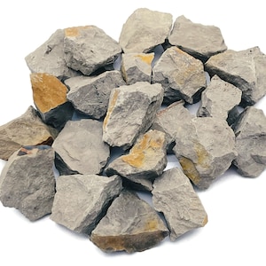 May include: A pile of rough, grey and brown clay rocks. The rocks are irregular in shape and size.