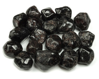 May include: A collection of tumbled black gemstones, likely black tourmaline or obsidian, with a smooth, polished finish. The stones are various sizes and shapes, with a dark, opaque appearance.