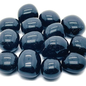 May include: A collection of tumbled black obsidian stones. The stones are smooth and polished, with a deep black colour.