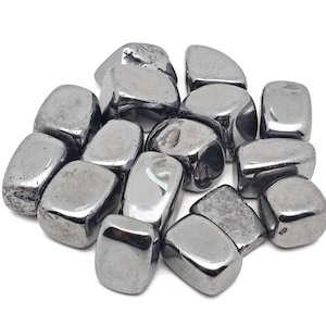 Puede incluir: Una colección de piedras de hematites pulidas, cada una con una superficie lisa, brillante y de color negro metálico.