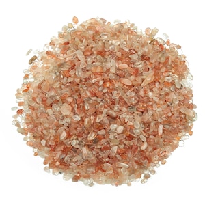 May include: A pile of small, translucent, orange-red crystals. The crystals are irregularly shaped and have a natural, rough texture.