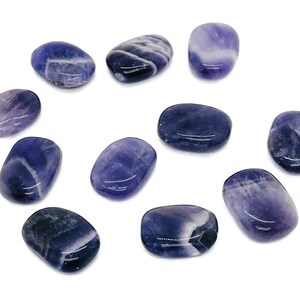 Peut inclure: Une collection de 10 pierres d'améthyste lisses de forme ovale. Les pierres sont d'une couleur violet foncé avec des stries blanches.