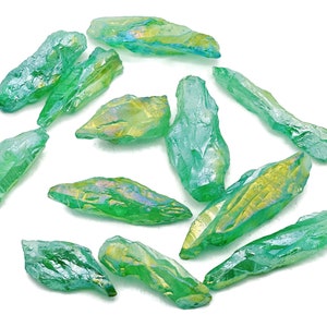 May include: A collection of green iridescent quartz points, also known as angel aura quartz, with a variety of sizes and shapes.