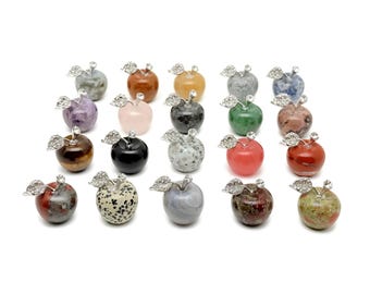 May include: A collection of 20 gemstone apple figurines. Each apple is carved from a different type of gemstone, including amethyst, rose quartz, tiger's eye, and jasper. The apples are all about 2 inches tall and have a silver-toned metal stem and leaves.