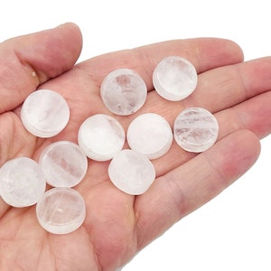 May include: A collection of ten smooth, white, round, polished, clear quartz crystal cabochons. The cabochons are approximately 2.5 cm in diameter.