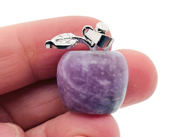 May include: A purple amethyst apple charm with a silver leaf and stem pendant.