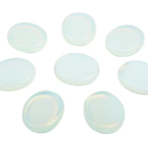 May include: Eight oval-shaped, smooth, white opal stones. The stones are arranged in a circle on a white background.
