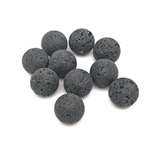 Könnte beinhalten: Zehn schwarze Lavasteine, jede mit einer rauen, porösen Oberfläche.