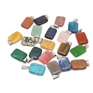 Pode incluir: Conjunto de 16 pingentes retangulares de pedra coloridos com argolas de prata. Cada pingente apresenta uma pedra natural diferente, incluindo verde, azul, vermelho, marrom e amarelo.
