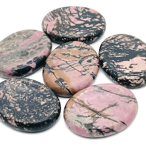 May include: Six pink and black polished oval-shaped stones. The stones have a marbled pattern with black veins and pink and white swirls.