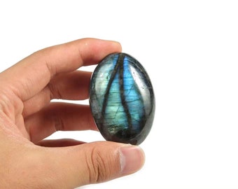 May include: A smooth, oval-shaped labradorite gemstone with iridescent blue and green colours.