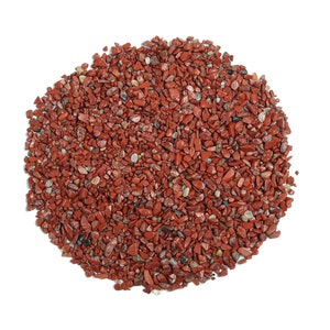 May include: A close-up of a pile of small, red, and brown stones. The stones are irregularly shaped and have a rough texture.
