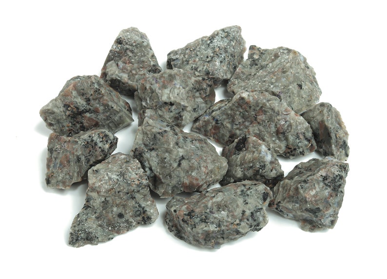 May include: A pile of small, gray and black granite rocks. The rocks are irregularly shaped and have a rough texture.