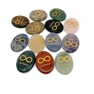 May include: A collection of oval-shaped gemstone pendants in various colors, including green, red, and blue. Each pendant features a gold infinity symbol and the word "Infinity". The pendants are arranged on a white surface.