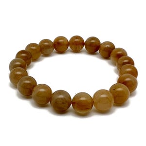 Op de afbeelding: Een bruine edelsteen armband met ronde kralen.