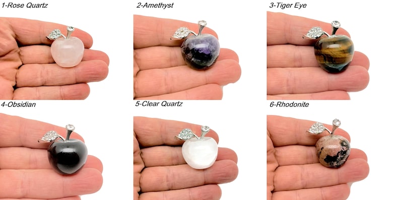 May include: Six different crystal apple pendants, each with a silver setting and a crystal stone. The stones are rose quartz, amethyst, tiger eye, obsidian, clear quartz, and rhodonite.