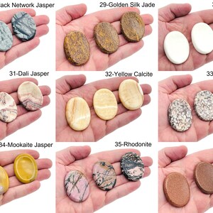 Peut inclure: Une collection de 10 types de pierres polies diff&eacute;rentes, chacune avec une couleur et un motif uniques. Les pierres sont dispos&eacute;es en trois rang&eacute;es de trois, avec le nom de chaque pierre inscrit au-dessus. Les pierres sont toutes de forme ovale et lisses au toucher.
