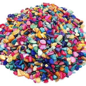 May include: A large pile of colourful, iridescent, and multi-shaped shell pieces. The shell pieces are a mix of blue, green, red, orange, yellow, and white.