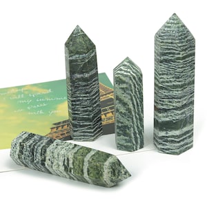 Może przedstawiać: Cztery zielone i białe, paskowane kryształowe szpice o r&oacute;żnych rozmiarach. Szpice są gładkie i wypolerowane.