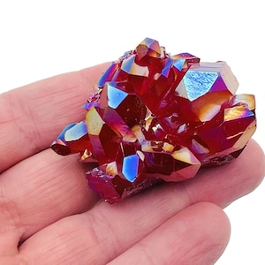 Op de afbeelding: Een cluster van rode, iriserende kwartskristallen met een regenboogkleurige glans. De kristallen zijn scherp en puntig en zijn in een willekeurig patroon gerangschikt. De kristallen zijn ongeveer 5 cm in diameter.