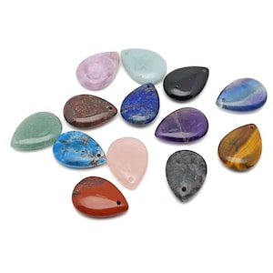 May include: A collection of teardrop-shaped gemstones in various colors, including green, blue, purple, and brown. Each stone has a small hole for stringing. The gemstones are arranged on a white background.