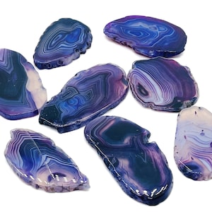 May include: Eight purple agate slices with white and blue banding. The agate slices are smooth and polished.