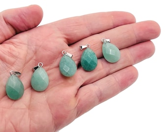May include: Five green gemstone pendants with silver bail settings. The pendants are teardrop shaped and have a faceted finish.