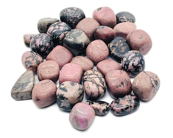 May include: A collection of tumbled pink and black stones. The stones are smooth and polished, with a variety of patterns and textures.