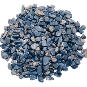 Peut inclure: Un tas de galets polis bleu foncé de formes arrondies. Les pierres varient en taille et présentent un aspect naturel et terreux. Certains galets présentent des nuances de brun et de gris, créant un aspect texturé. Le fond est blanc uni.