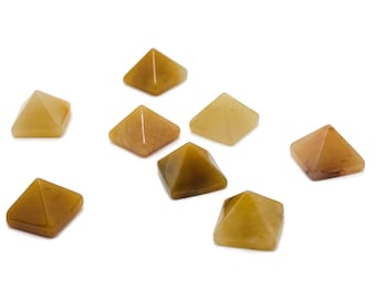 Peut inclure: Huit petites pyramides en pierre précieuse jaune doré. Les pyramides sont en pierre polie et ont une surface lisse et brillante.