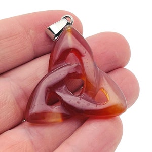 May include: A red carnelian gemstone pendant in the shape of a Celtic knot, with a silver bail.