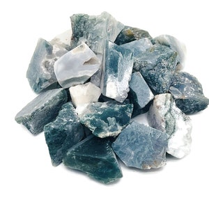 Puede incluir: Un montón de piedras de ágata verde y blanca. Las piedras son ásperas y tienen un aspecto natural y sin pulir.